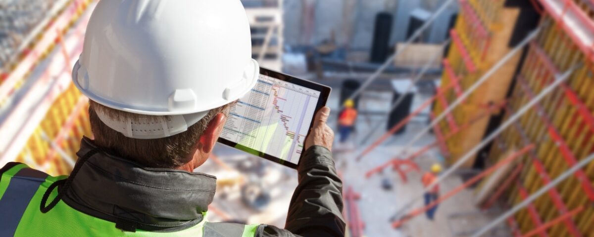 man looking at digital document on tablet at construction site