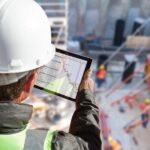 man looking at digital document on tablet at construction site