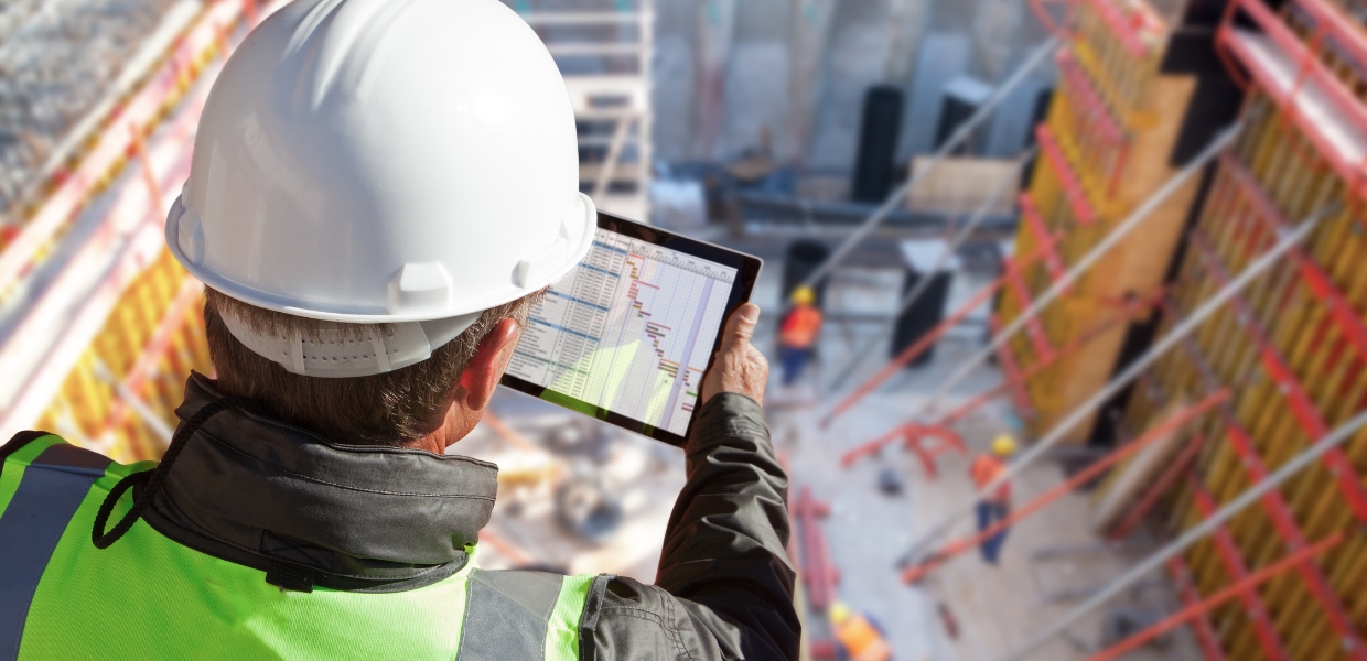 man looking at digital document on tablet at construction site